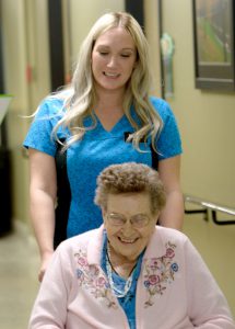 Woman in wheelchair with nurse.